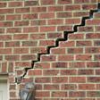 stair step cracking reaching from a window along the foundation wall in Macon