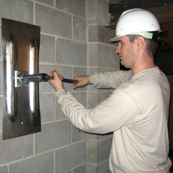 installing a wall anchor to repair an bowing foundation wall in Fayetteville