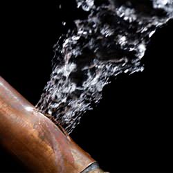 A bursting copper pipe in North Charleston, with water gushing out.