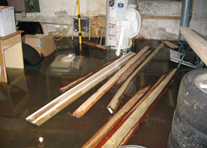 A severely flooding basement in Hilton Head Island, with lumber and personal items floating in a foot of water